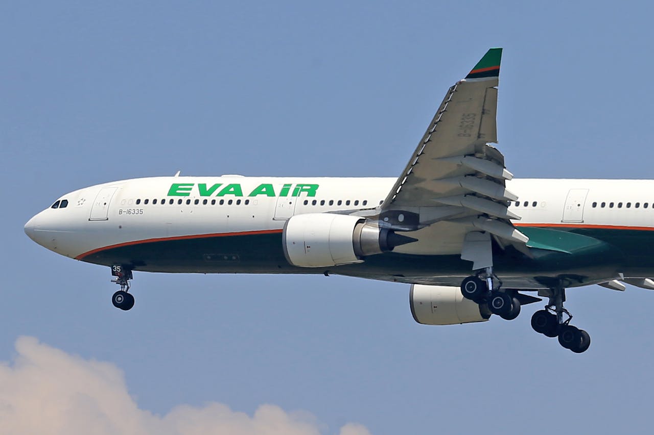 A large green and white airplane flying in the sky